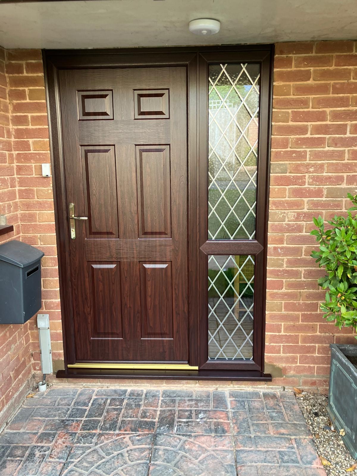 Walnut-effect panelled front door with leaded side panel